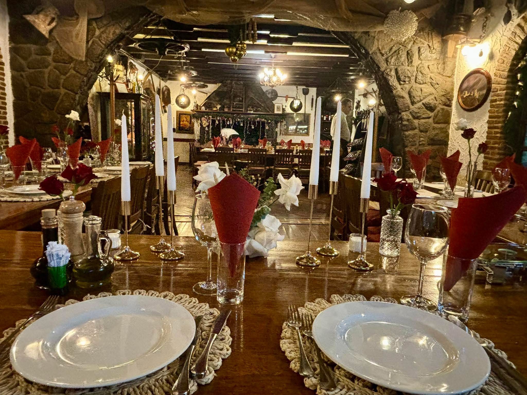 Stone-walled interior of Konoba Tarsa with set wooden tables and candles