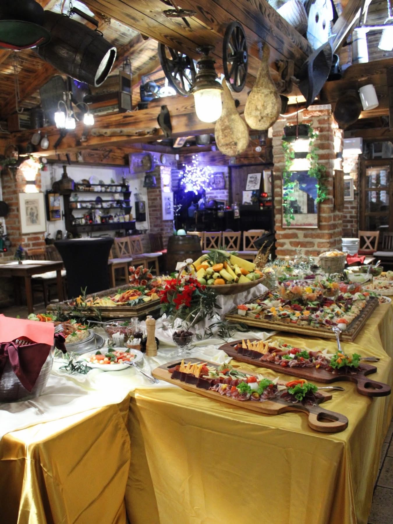 Buffet table draped in gold cloth laden with platters and charcuterie boards