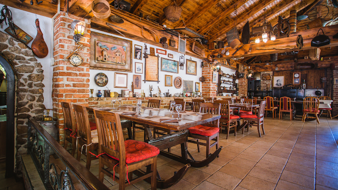 Main dining room with brick walls, beamed ceiling and antique decor