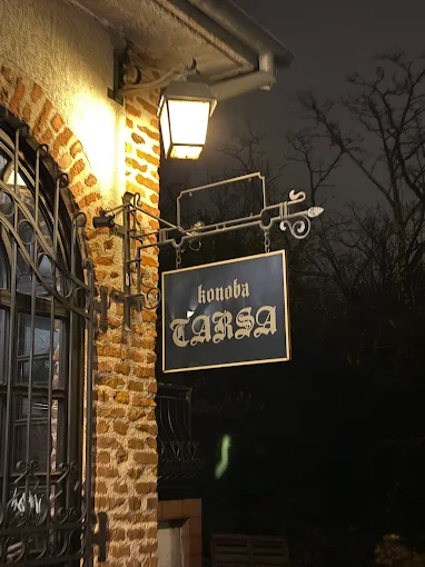 Konoba Tarsa sign lit by a lantern at night