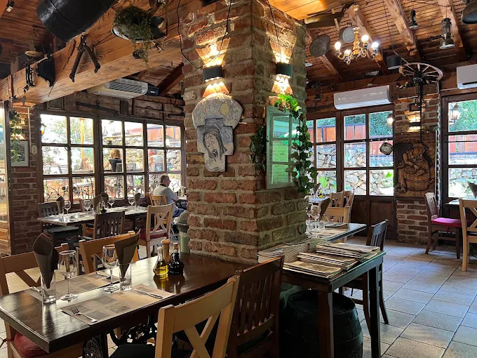 Dining room with brick pillar, lanterns and tables set by the windows