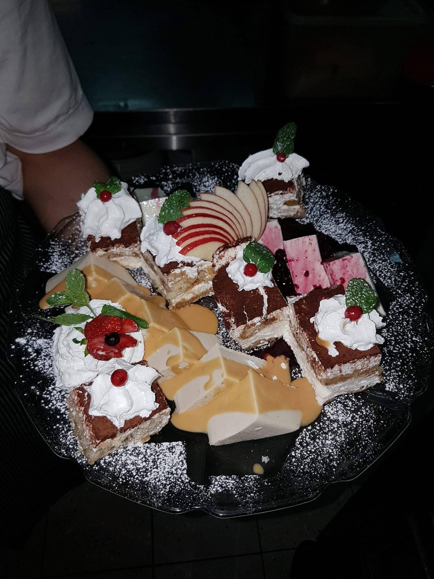 Dessert platter of cakes, flan and apple slices dusted with powdered sugar