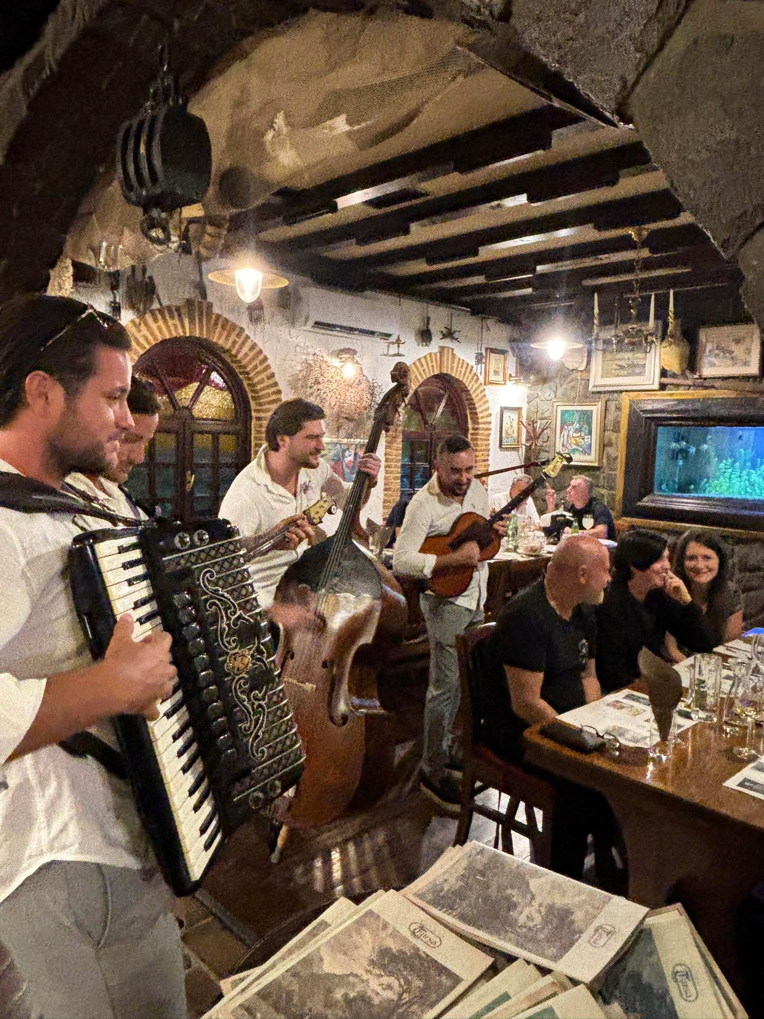 Live musicians playing accordion, double bass and guitar for diners