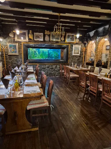 Stone-walled dining room with wooden floor and aquarium