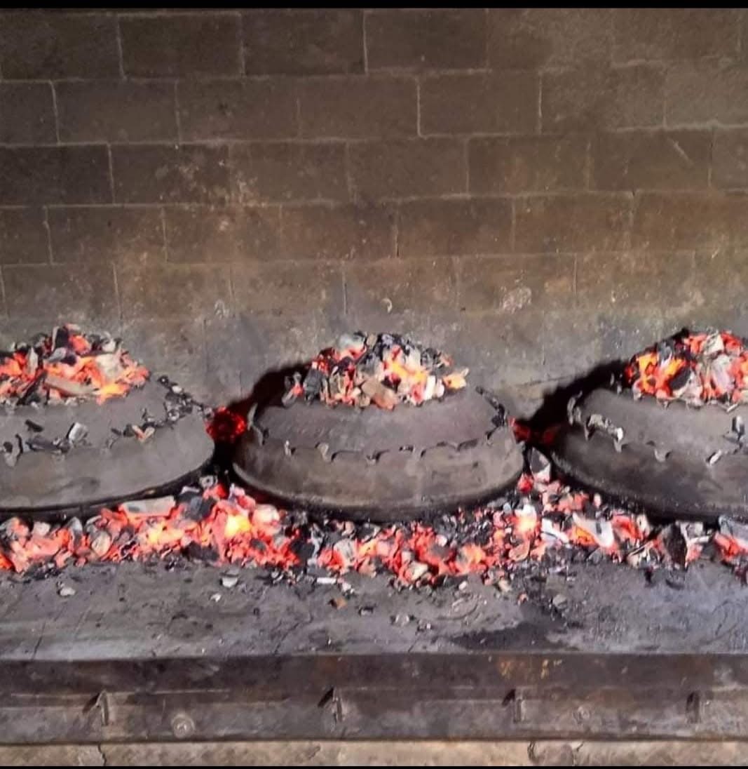 Traditional peka domes cooking under glowing coals